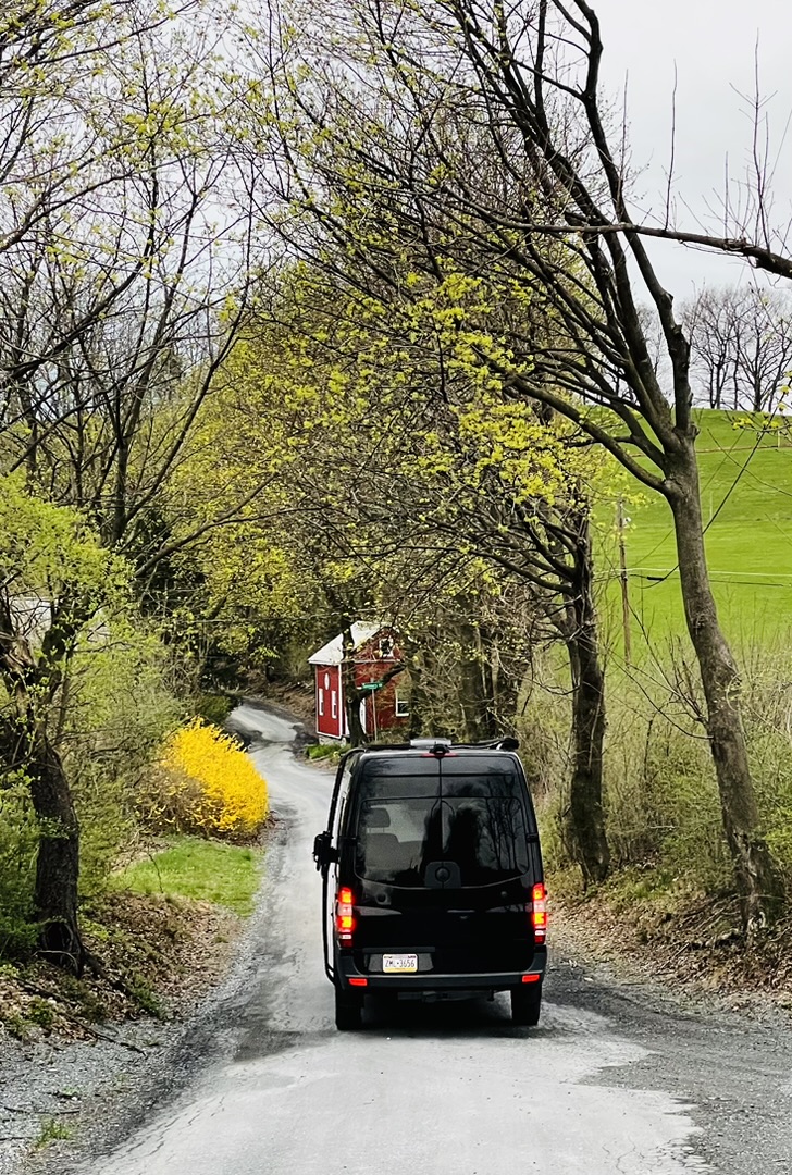 Black Keystone camper van traveling a winding country road